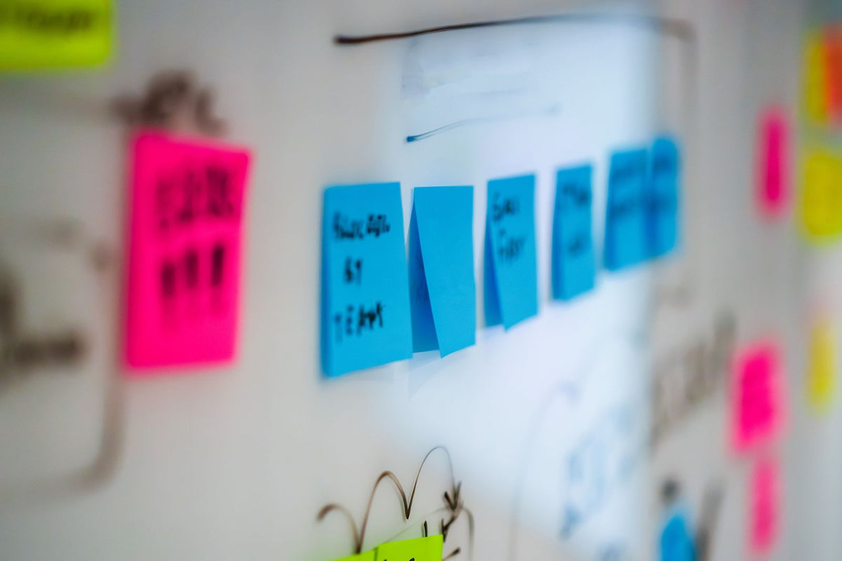 Colourful sticky notes arranged on a whiteboard during a brainstorming session in an office
