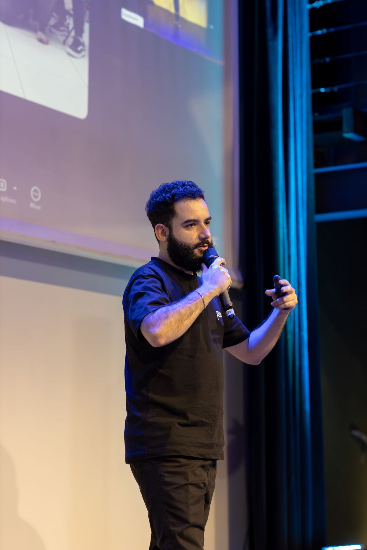 Speaker presenting on stage to an audience at a business technology conference