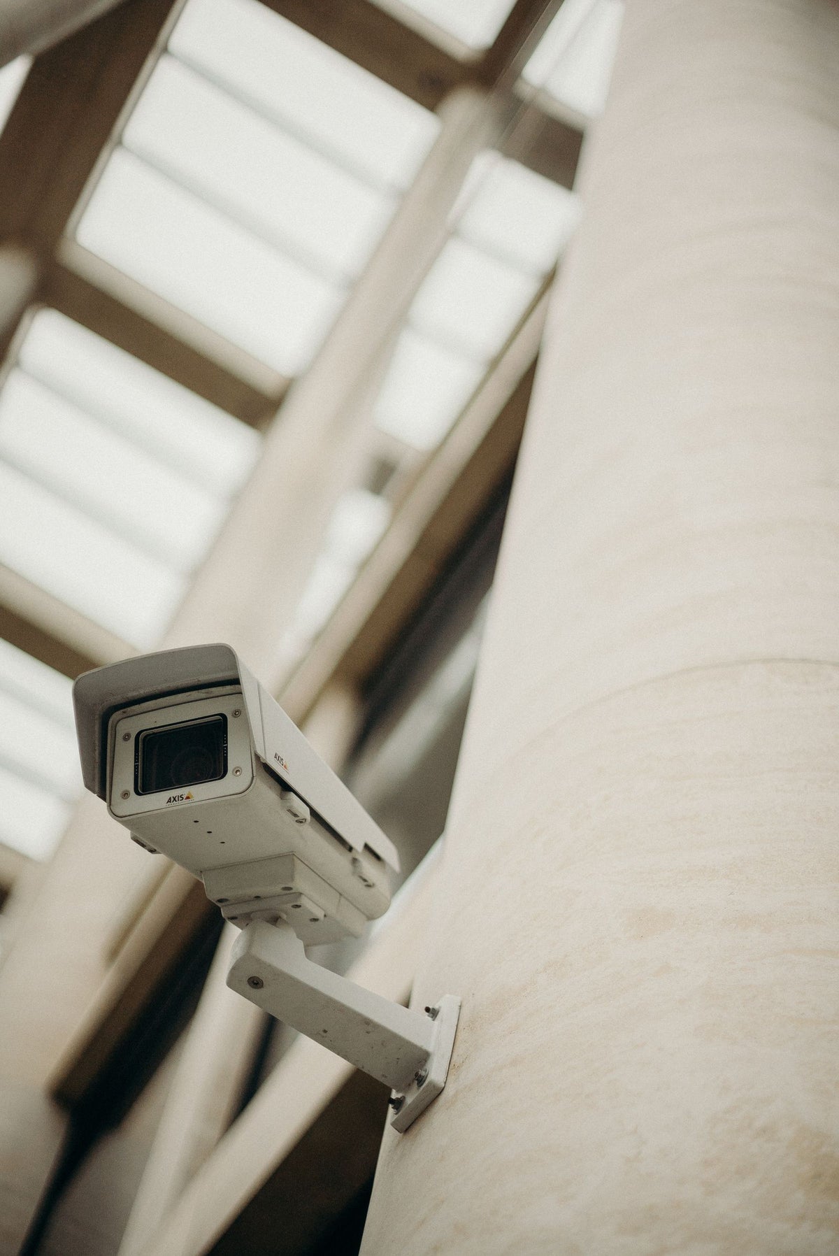Close-up of a white security camera mounted on a building wall