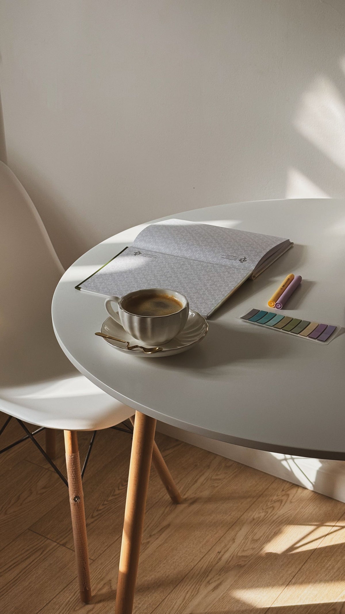 An open notebook and a cup of coffee on a table, ready for note-taking during customer discovery interviews