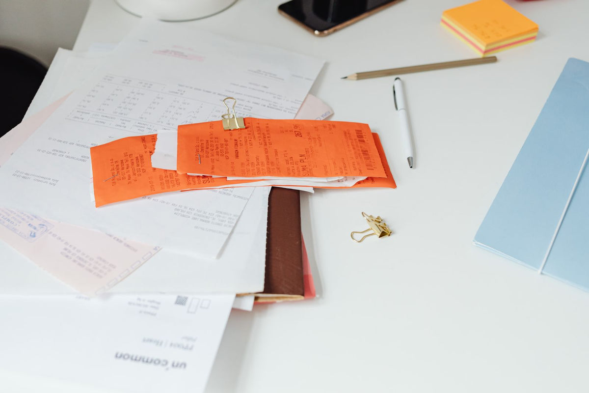 Tidy office desk with paper receipts, invoices and stationery ready for bookkeeping