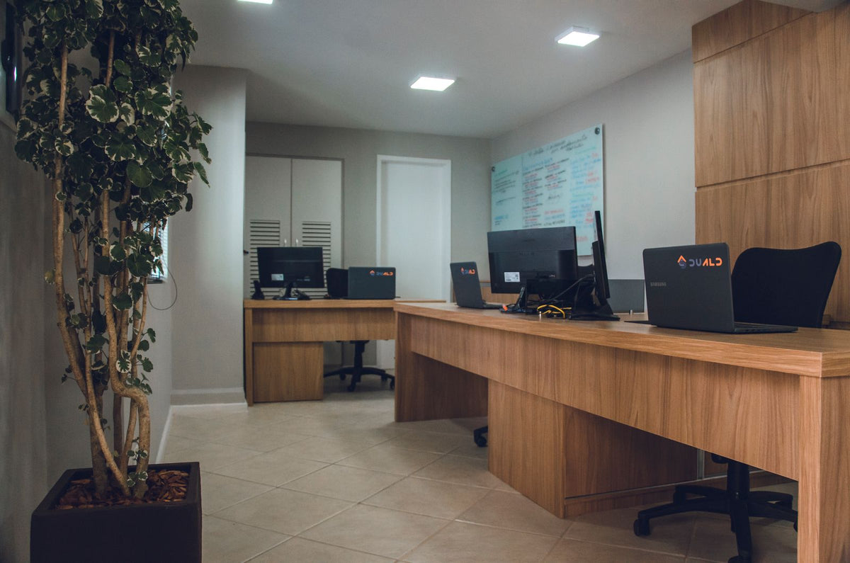Empty modern open-plan office with computer workstations and ergonomic chairs
