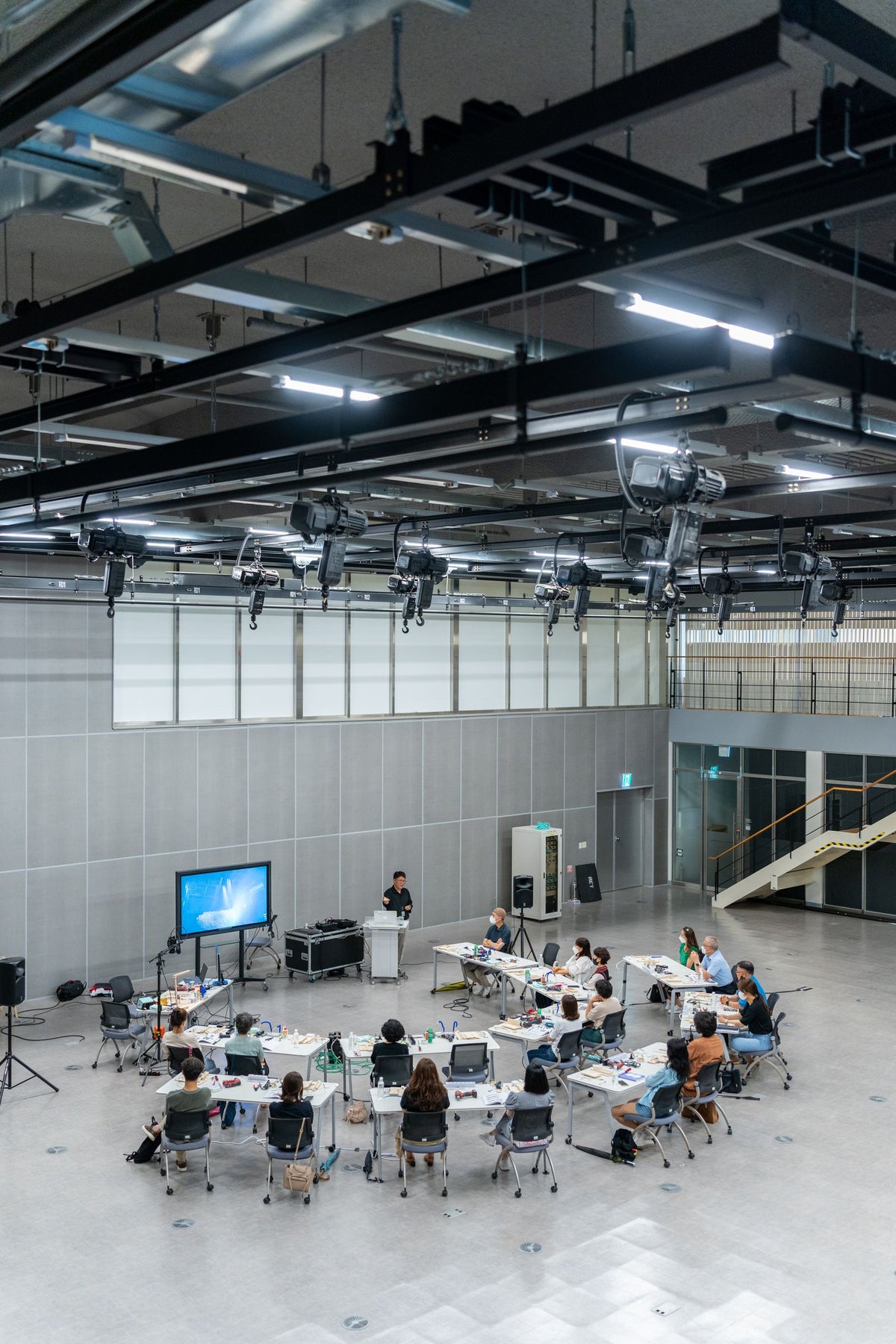 Overhead view of a modern conference room with rows of desks facing a presentation screen