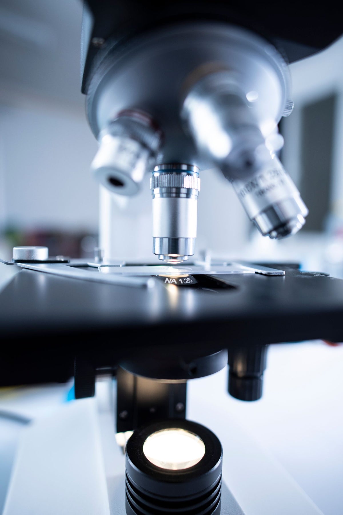 Close-up of a laboratory microscope's lenses and optical components, representing research turning into innovation