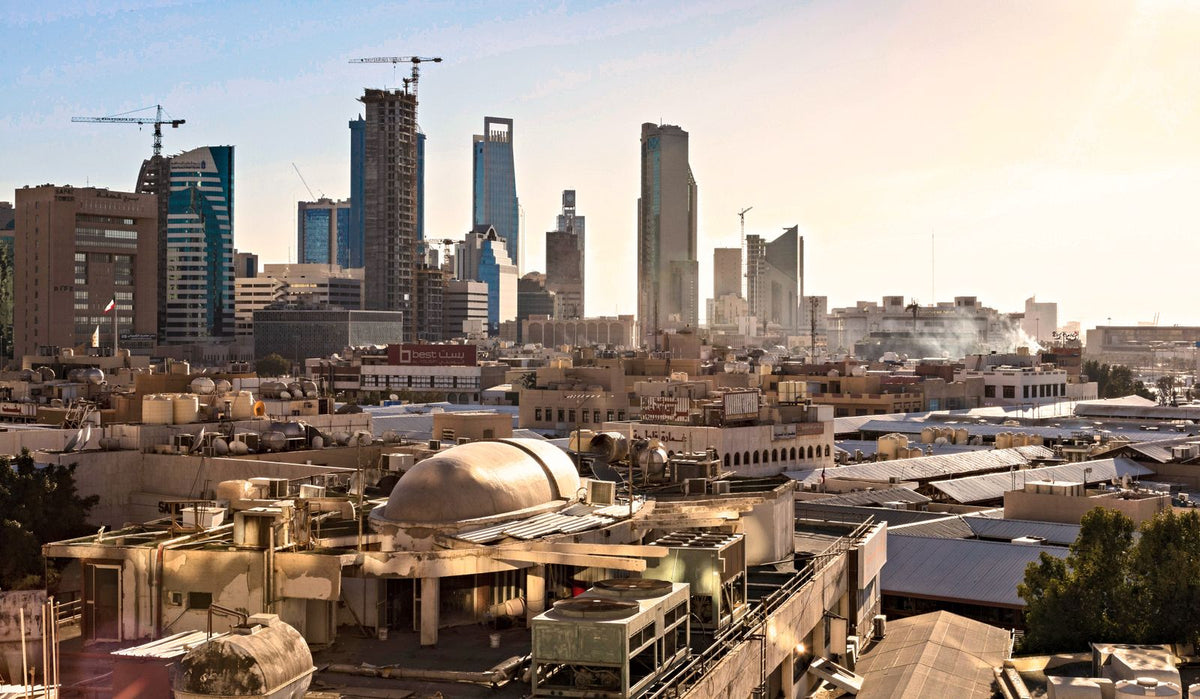 Riyadh skyline with modern skyscrapers and construction cranes at sunset