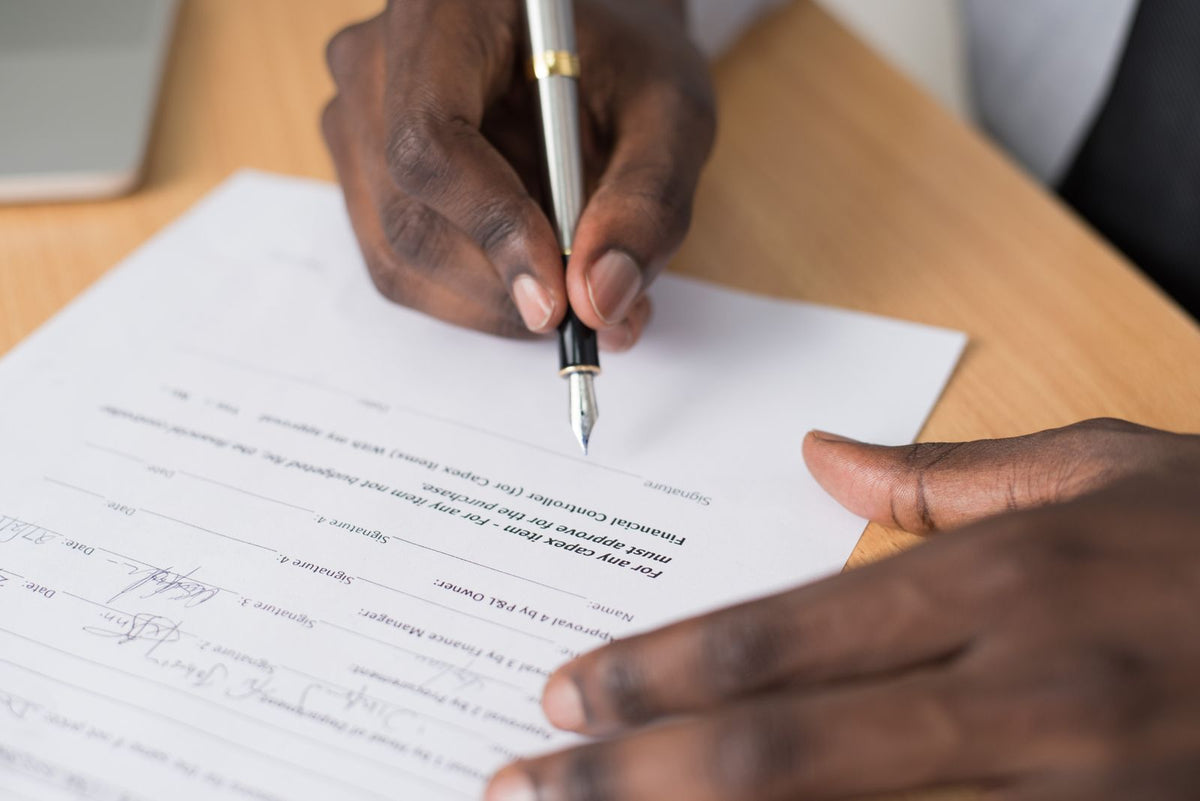 Close-up of hands signing an employment contract with a pen